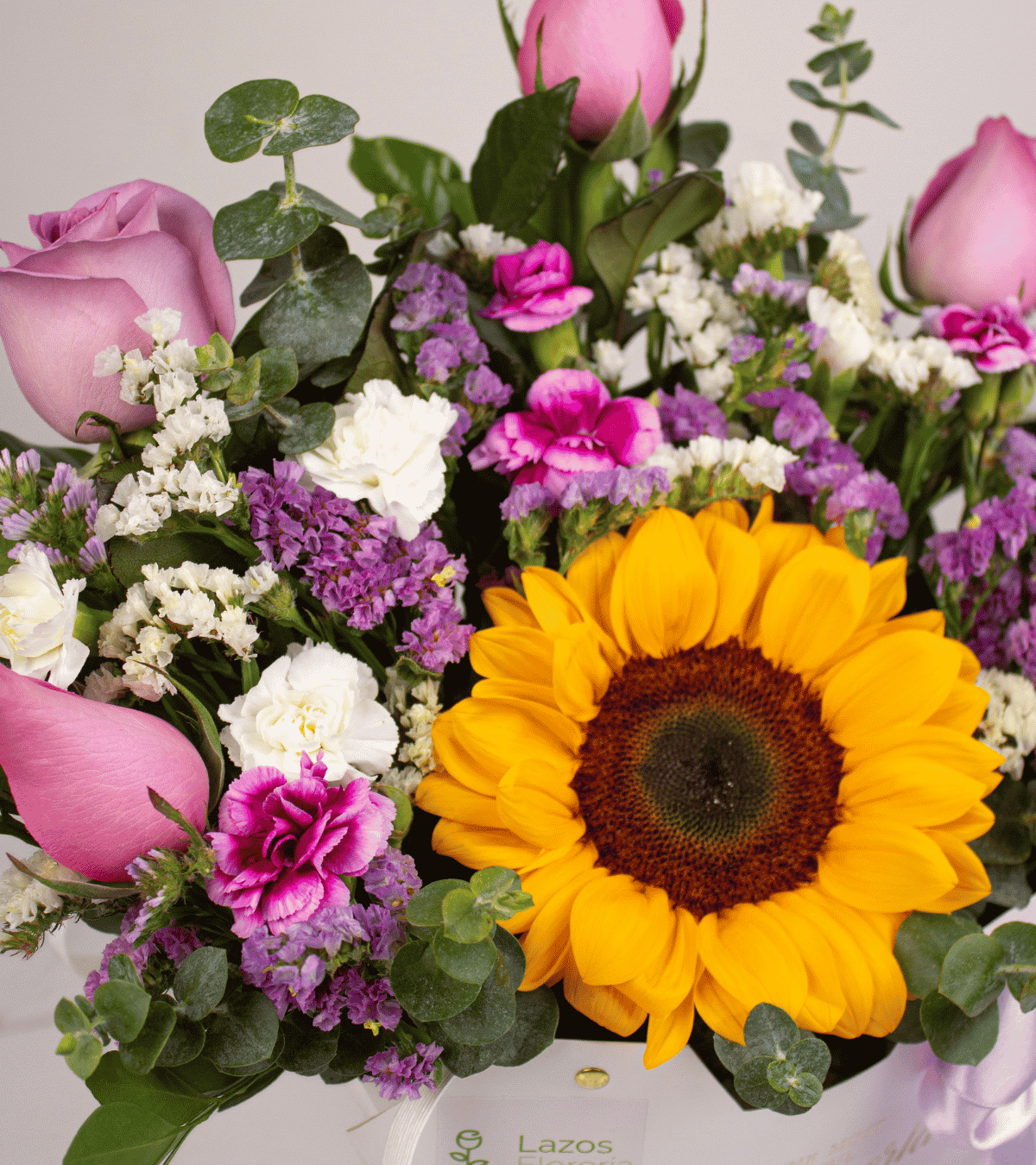 Box tipo cartera con un girasol grande y rosas rosas ideal para sorprender por aniversario con delivery en Lima.
