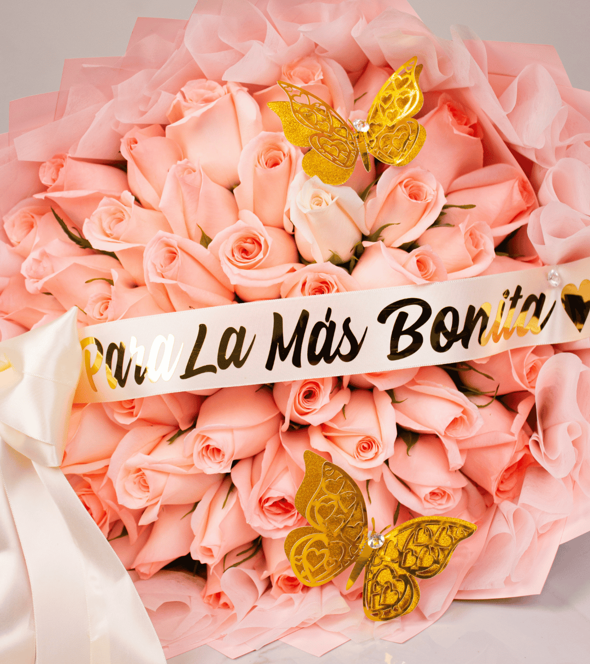 Ramo de rosas rosadas con mariposas doradas y cinta de para la más bonita para regalo de aniversario en Lima de Florería Lazos.