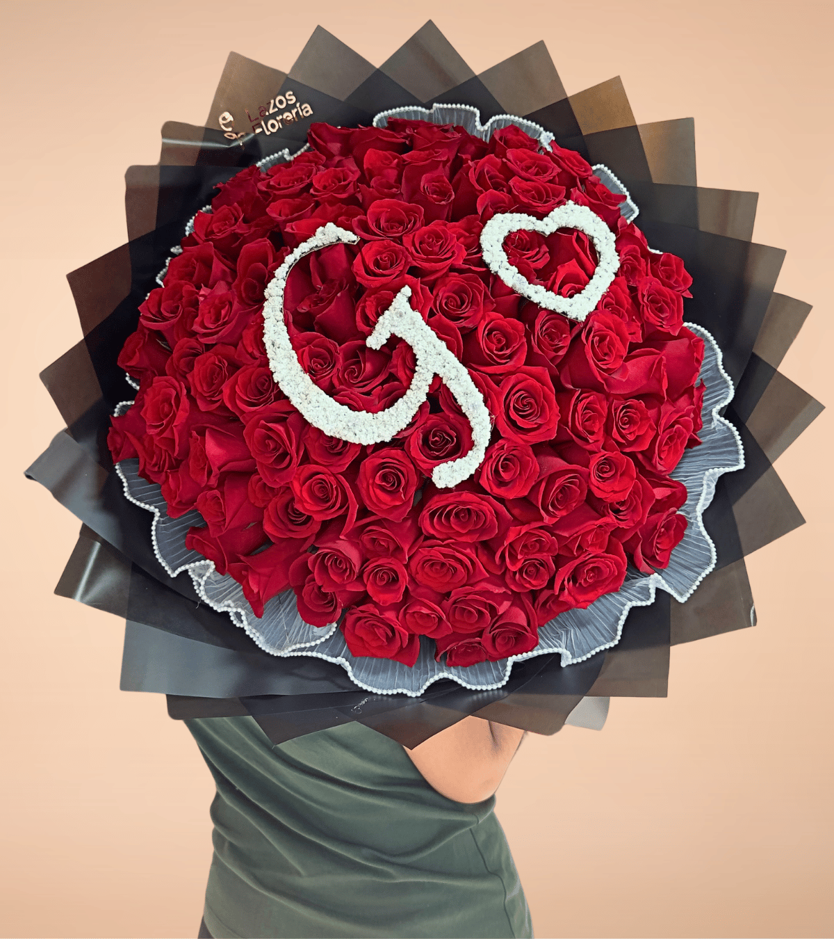 Ramo buchón de 100 rosas rojas con letra y corazón personalizado en envoltura negra para aniversario en Lima de Florería Lazos.