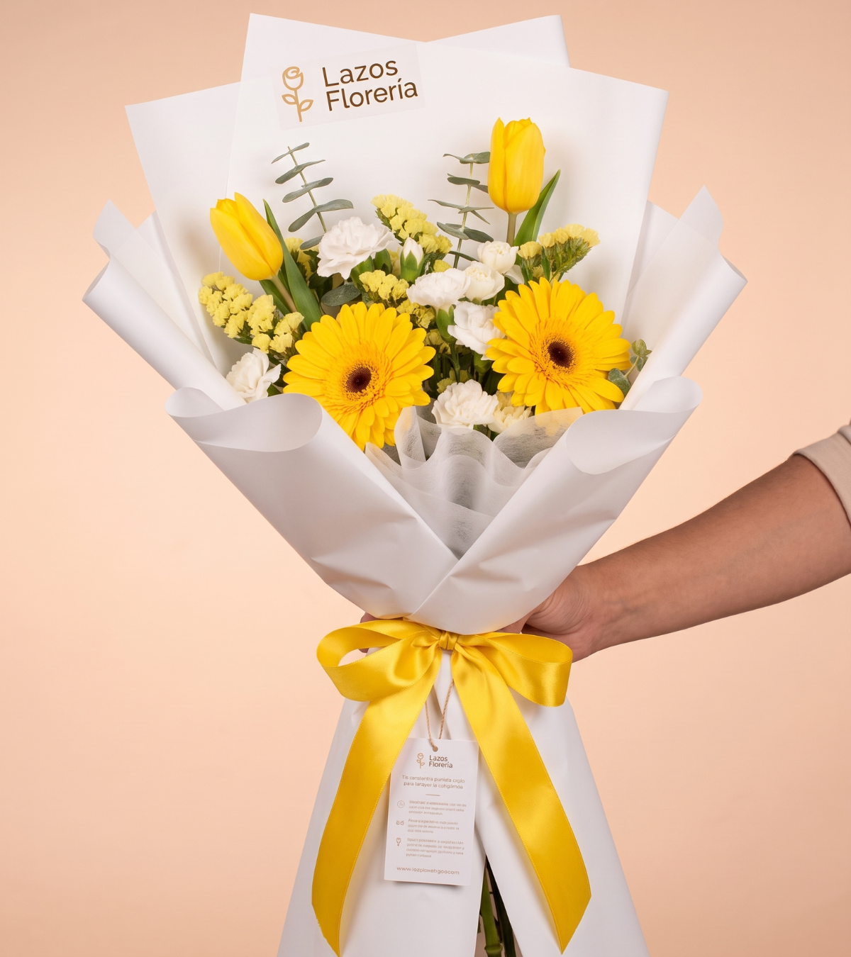 Ramo de gerberas amarillas, tulipanes y claveles blancos en envoltura blanca con lazo amarillo para regalo de cumpleaños en Lima de Florería Lazos.