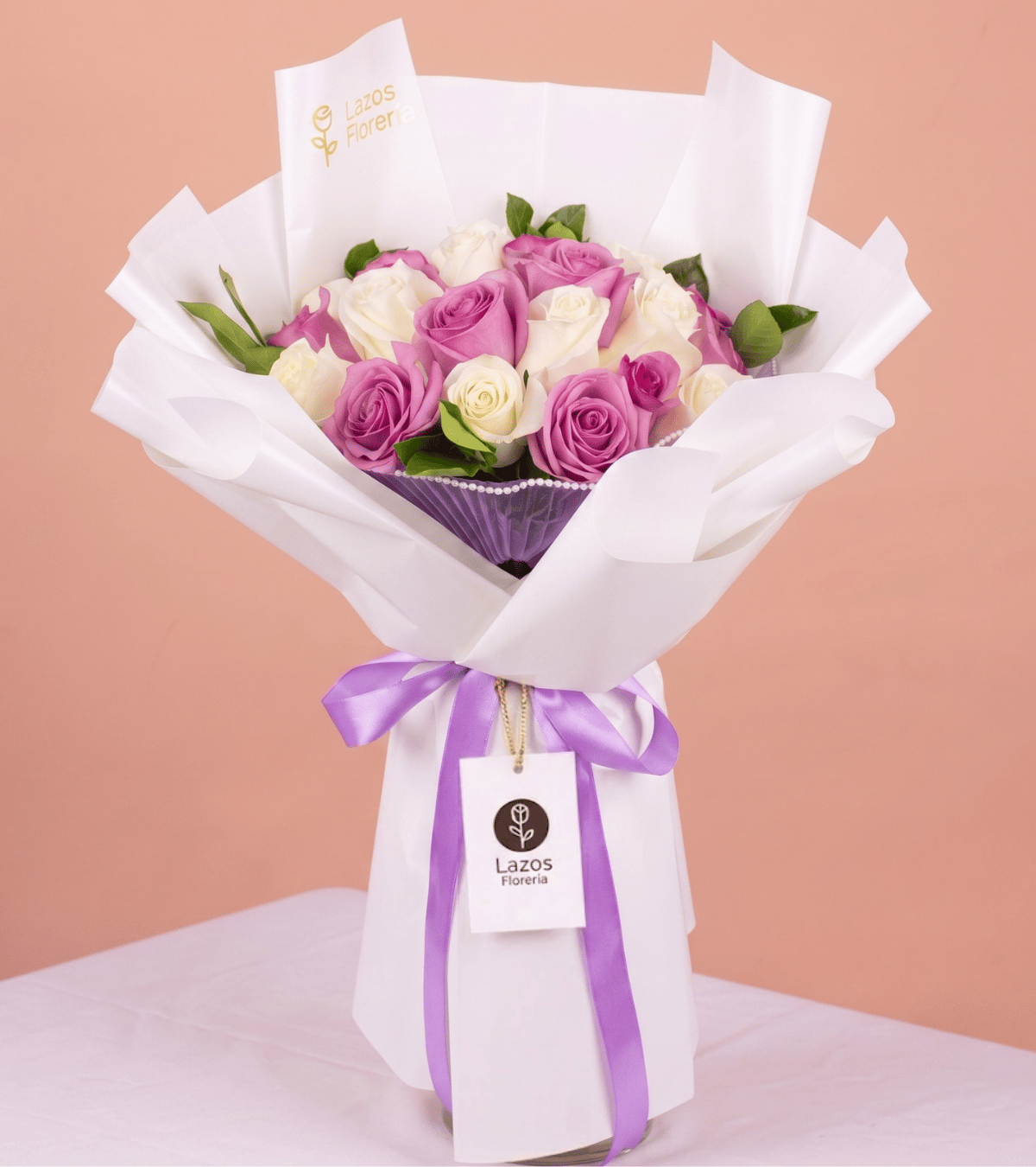 Ramo de rosas moradas y blancas con detalle de perlas en envoltura blanca para regalo de cumpleaños en Lima de Florería Lazos.