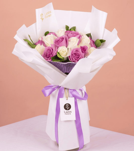 Ramo de rosas moradas y blancas con detalle de perlas en envoltura blanca para regalo de cumpleaños en Lima de Florería Lazos.