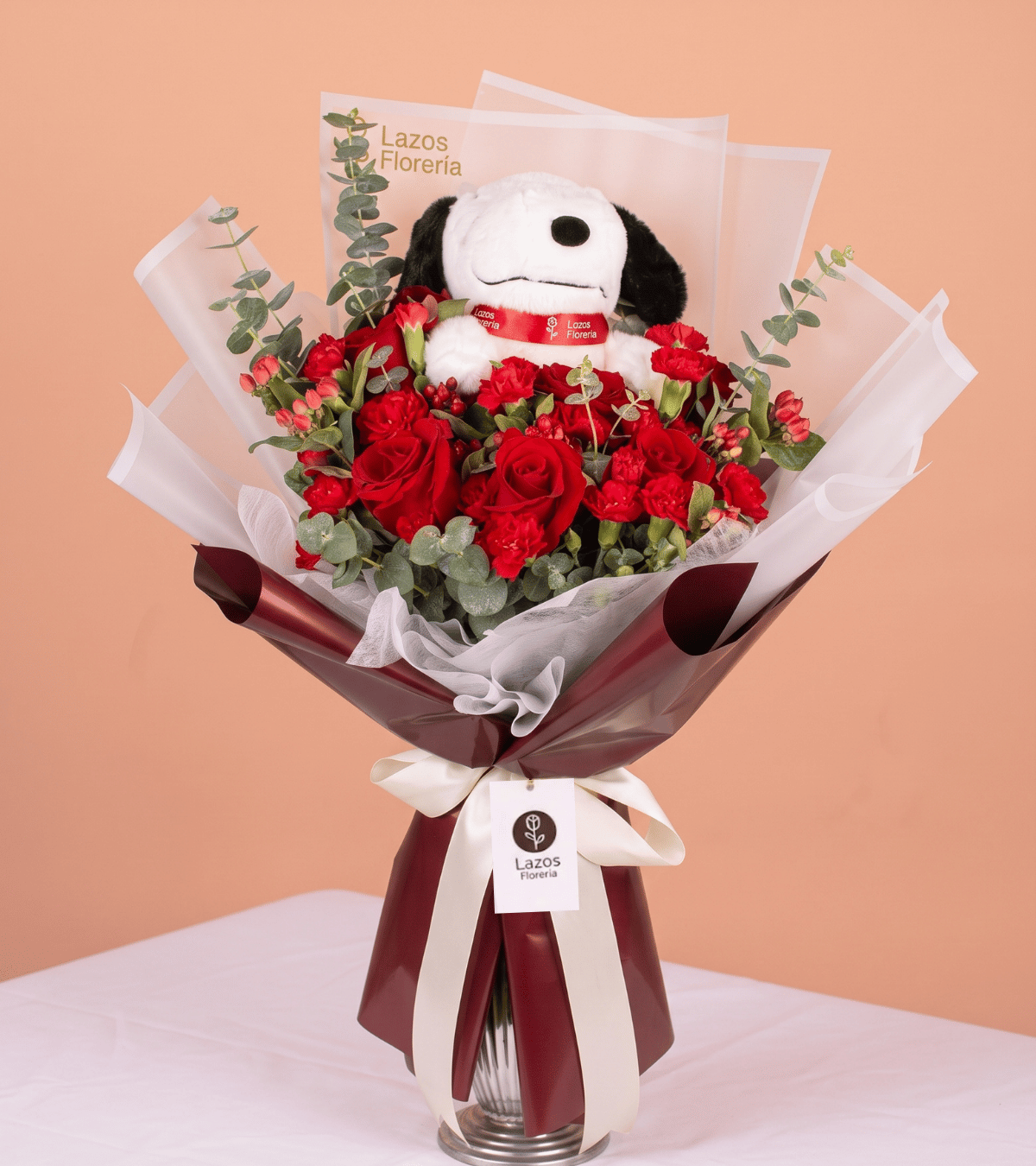 Ramo de rosas rojas con peluche y envoltura color vino para regalo de aniversario en Lima de Florería Lazos.