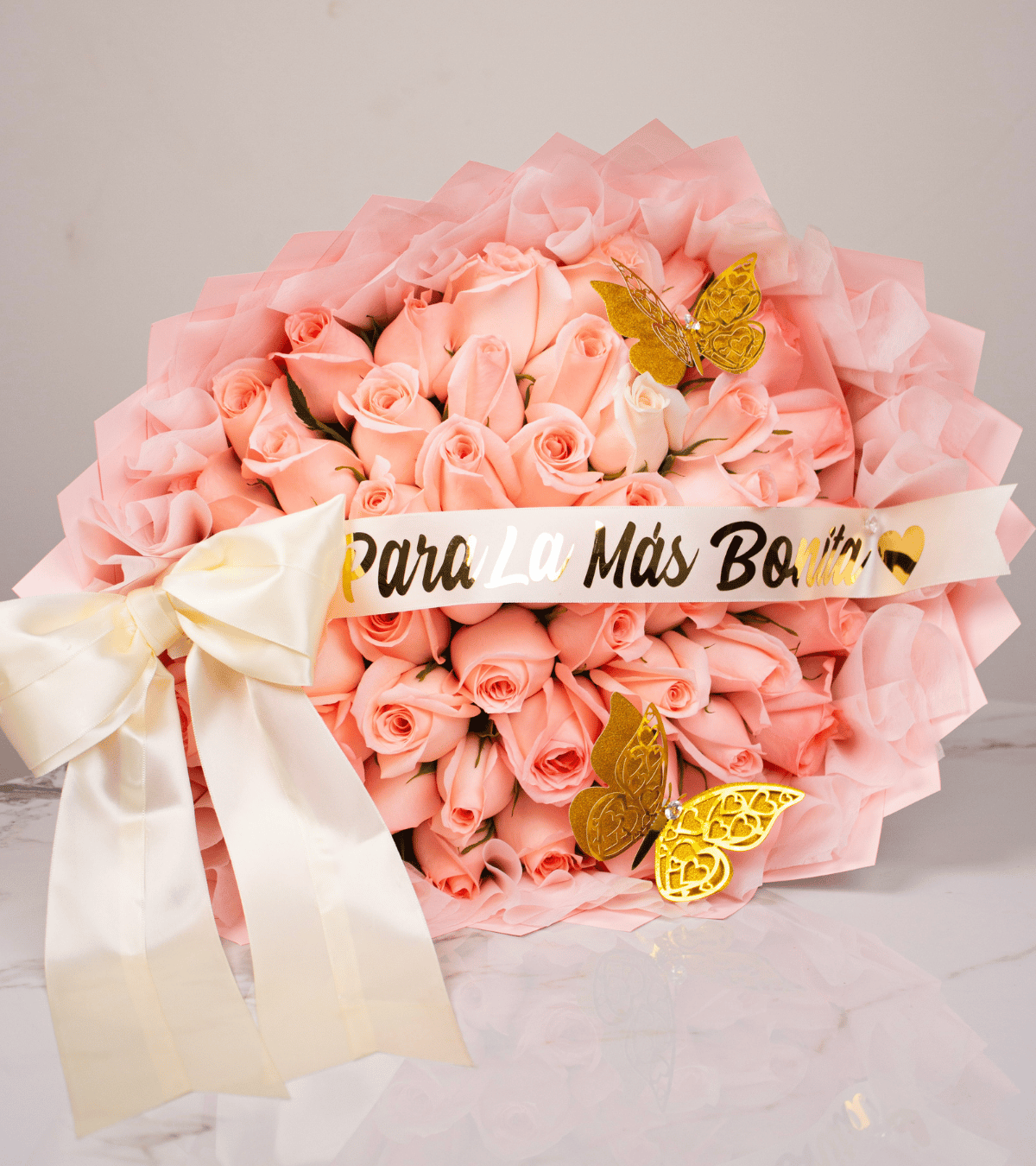 Ramo de rosas rosadas con mariposas doradas y cinta de para la más bonita para regalo de aniversario en Lima de Florería Lazos.