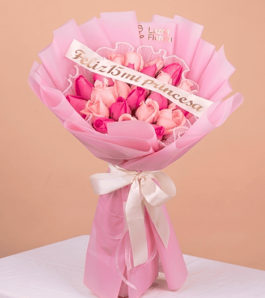 Arreglo de rosas en tonos rosados con banda de feliz quince años ideal para obsequio de quinceañera con delivery en Lima.